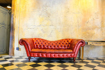 red sofa at old blick wall  on Checkered floor