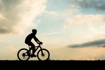 Obraz na płótnie Canvas Silhouette of cyclist motion on sunset background