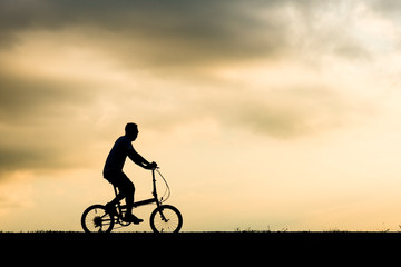 Obraz premium Silhouette of cyclist motion on sunset background