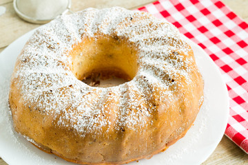 Uncut homemade bundt cake with icing sugar.