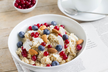 Homemade oatmeal with bluberries, almond and red currant for healthy breakfast.