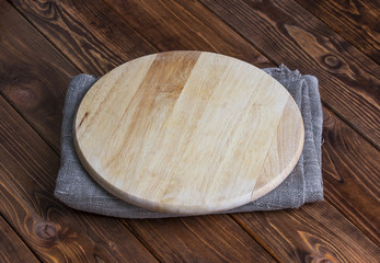 Background for product montage. Empty round wooden board with tablecloth.