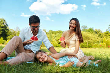 Fototapeta premium Family In Park. Happy Young Parents And Child Relaxing Outdoors