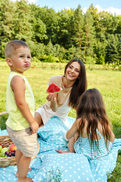 Mother With Children Having Fun In Park. Happy Family Outdoors