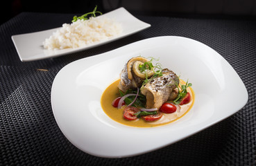 dorado with rice on white plate