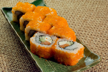 Salmon, sakura sushi roll on green plate