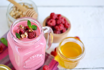 Berry smoothie in a glass jar on the breakfast with raspberries,