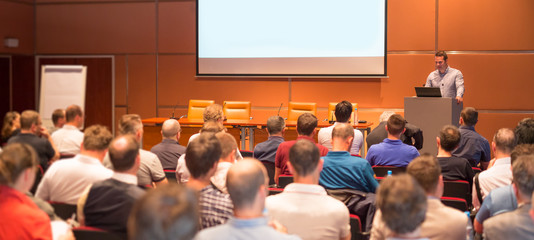 Speaker giving a talk in conference hall at business event. Audience at the conference hall....