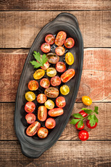 Sliced colorful cherry tomatoes with oil and spice