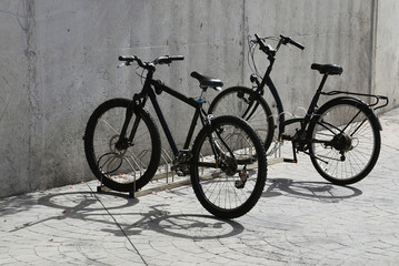 Fototapeta na wymiar Two bicycles near a wall in sunny day.