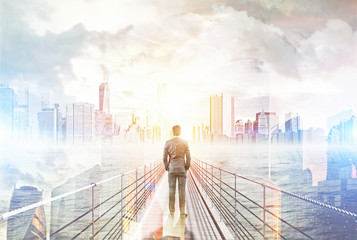 Man standing on bridge and looking at big city