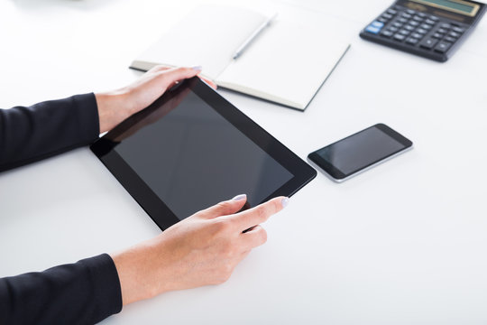 Woman's hands holding tablet computer in office