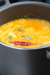 indian yellow dahl cooking in a black pot lentil soup