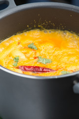 indian yellow dahl cooking in a black pot