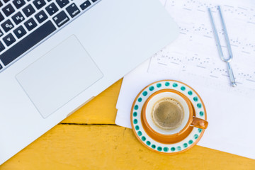 Laptop, cup of coffee, tuning fork and musical notes
