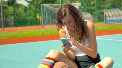 Athletic girl sitting on the sports field and browsing internet on smartphone
- Powered by Adobe