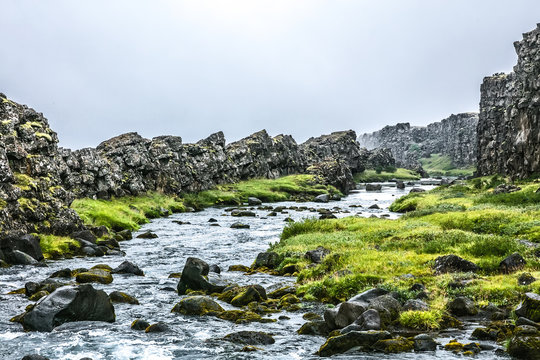 Summer Iceland landscape with river, sharp stones and grass