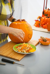 Closeup on housewife prepare big pumpkin for Halloween party