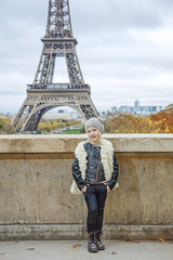 smiling trendy child in front of Eiffel tower in Paris, France
