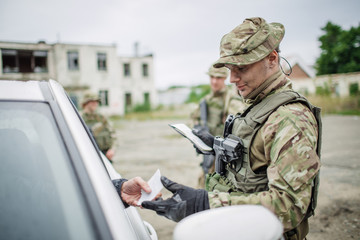 soldiers at the checkpoint stopped a car.