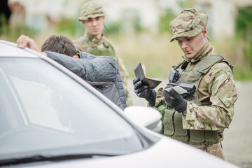 soldiers at the checkpoint stopped a car.