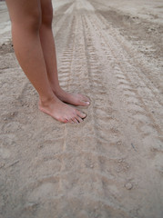 Children stand barefoot on the ground.