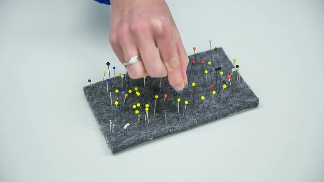 Collecting colorful pins in cushion