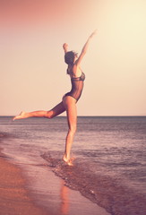 Fototapeta na wymiar Black bikini sea, jump ballet, landscape, toned