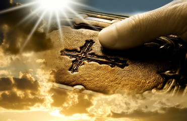 Man hand keeping the bible over mystic rays of light like a concept for a prayer