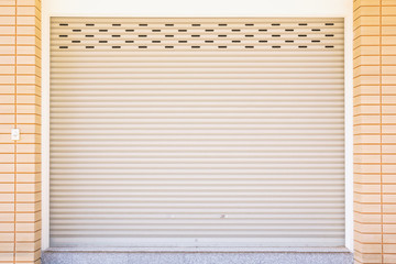 Metal roller door shutter and brick wall.