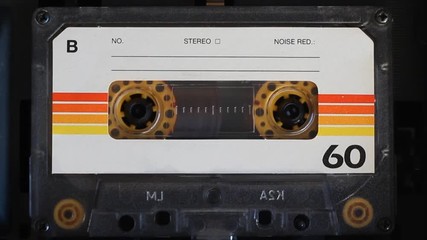 Vintage audio cassette tape playing, macro. Top view. Blank label.