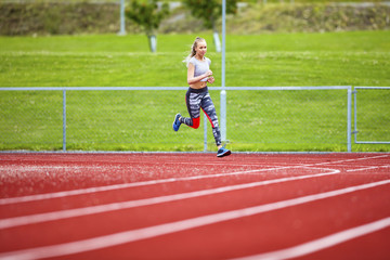 Fototapeta premium Determined Young Woman Running On Sports Tracks