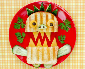 Fun Halloween monster sandwich with bread, cucumber and cheese