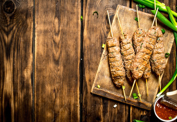 Kebab with green onions and hot sauce.