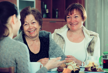 Fototapeta premium Young female and mature women drinking tea and talking