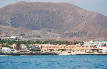 Fototapeta premium Fuerteventura, Isole Canarie: lo skyline di Corralejo con il Vulcano Bayuyo visti dall'Oceano Atlantico il 5 Settembre 2016