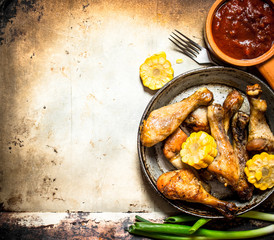 chicken legs with corn and tomato sauce.