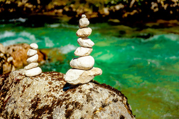 Fototapeta na wymiar beautiful wild river with turquoise water and stack of stone piles