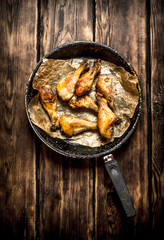 Fried chicken legs in frying pan.