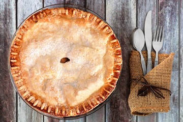 Delicious autumn apple pie, overhead table setting on a rustic wood background