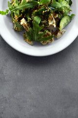 Tasty salad with chicken, cucumbers and arugula on plate