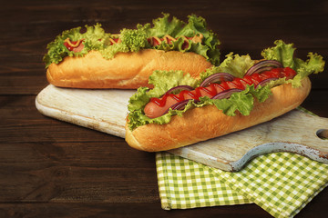 Delicious hot dogs on wooden board