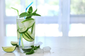 Cold fresh cocktail with lime on blurred window background