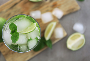 Cold fresh cocktail with lime on cutting board