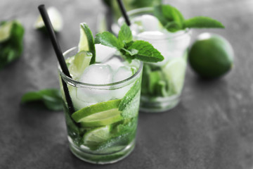 Cold fresh cocktails with lime on grey background