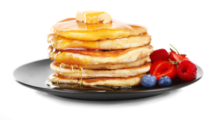 Tasty pancakes with fresh berries and sweet honey on plate, isolated on white