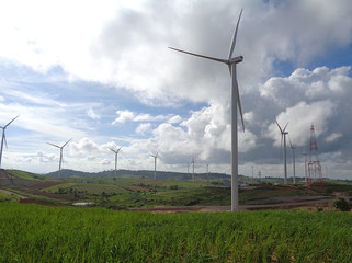 White Windmills on Green Hill against the Cloudy Sky 