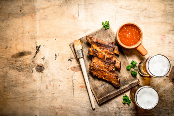 Smoked barbecue ribs with tomato sauce and cold beer.