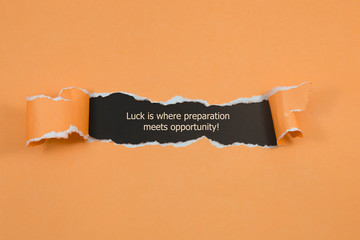 The quote Luck is where preparation meets opportunity, appearing behind torn paper.