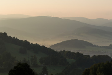 Mountain layer in morning sun ray and summer fog.